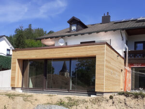 Einfamilienhaus mit Holzfassade und großer Glasfront