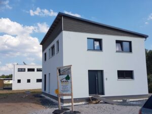 Weißes Einfamilienhaus mit Bauschild