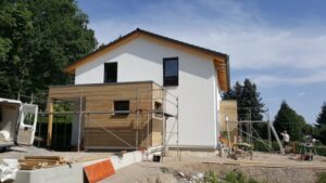 Einfamilienhaus im Rohbau mit Gerüst und weißer Fassade