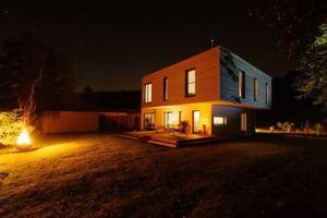 Modernes Einfamilienhaus mit beleuchteter Fassade bei Nacht