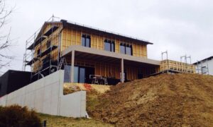 Holzhaus im Bau mit Gerüst und Holzfassade